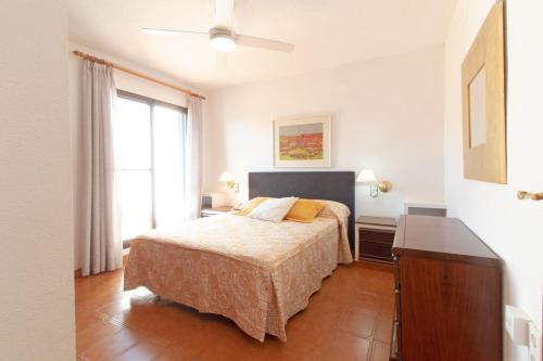 um quarto com uma cama, uma cómoda e uma janela em Global Properties, Adosado con piscina en la playa de Canet em Canet d'En Berenguer