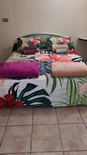 ein Bett mit einer bunten Decke darüber in der Unterkunft Vaiterupe Sweet Home in Orufara