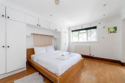 1 dormitorio con 1 cama grande, paredes blancas y ventana en Bright 1 Br Apt wpatio, next to Westfield Centre, en Londres