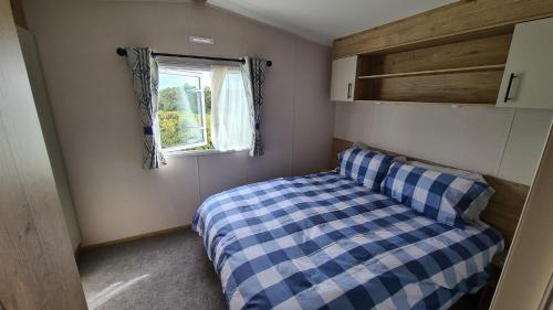 a small bedroom with a bed and a window at Madaisy in Lossiemouth