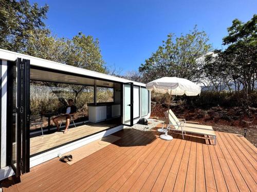 a person sitting on the deck of a house at Modern Off Grid Tiny Home! in Haleiwa