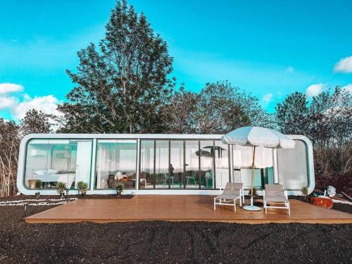 una casa con due sedie e un ombrellone di Modern Off Grid Tiny Home! a Haleiwa