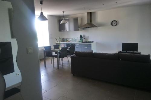 un salon et une cuisine avec un canapé et une table dans l'établissement Bel appart duplex moderne à 9 min de l'aéroport, à Janneyrias