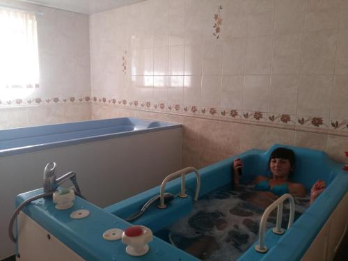 a man in a bath tub in a bathroom at Villa Kameliya in Truskavets