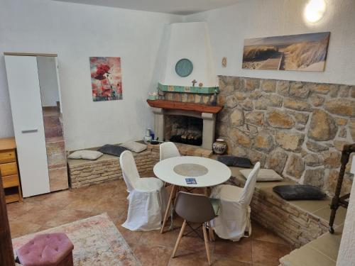 a living room with a table and a stone fireplace at Atelier apartment in Krasica