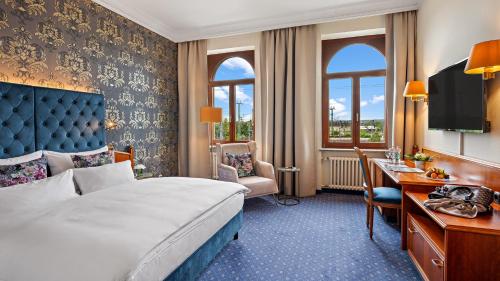 a hotel room with a bed and a desk at Hotel Bayerischer Hof Dresden in Dresden