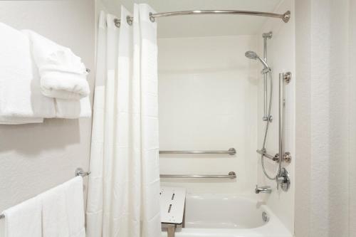 a bathroom with a shower with a white shower curtain at Holiday Inn Express Hotel & Suites Fort Lauderdale Airport/Cruise Port by IHG in Fort Lauderdale
