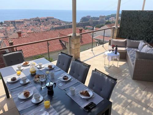 a table with plates of food on top of a balcony at Dalmatins MillionDollar sea view in Dubrovnik