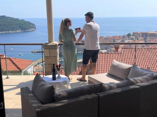 mężczyzna i kobieta stojący na balkonie w obiekcie Dalmatins MillionDollar sea view w Dubrowniku