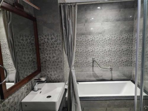 ein Bad mit einer Badewanne, einem Waschbecken und einer Dusche in der Unterkunft Green valley boutique in Paro