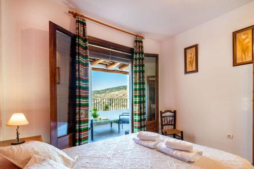 a bedroom with a bed with a view of a balcony at Casa Jose Capileira - Alpujarra in Capileira