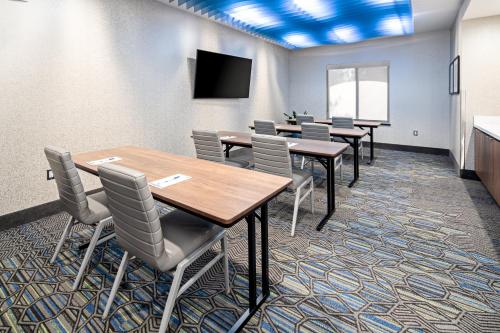 a conference room with tables and chairs and a screen at Holiday Inn Express Hotel & Suites Atascadero by IHG in Atascadero
