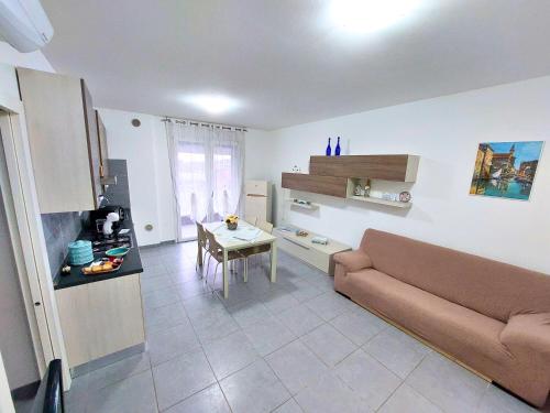 ein Wohnzimmer mit einem Sofa und einem Tisch in der Unterkunft Appartamento Palazzo Moretto in Chioggia