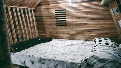 a room with a bed in a wooden cabin at Johns wooden cottages in Sultan Bathery