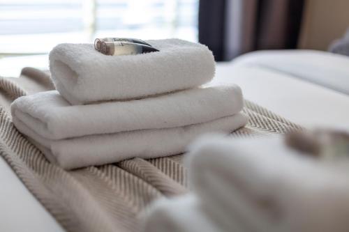 a pile of towels sitting on top of a bed at Bright Groundfloor 3BR Flat, Brockley, SE London in London