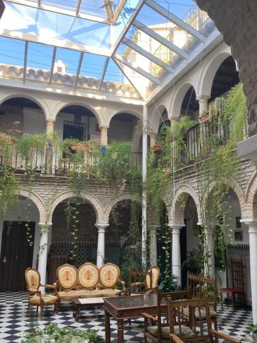 a conservatory with a table and chairs in a building at Hostal Palacio del Corregidor in Córdoba