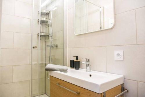 La salle de bains est pourvue d'un lavabo et d'une douche. dans l'établissement Appartement Vieux-Port de Marseille - Opéra, à Marseille