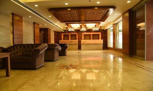 a large lobby with couches and tables and a floor at FabHotel Prime The Vijay Park in Chennai