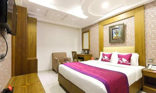 a hotel room with a large bed and a desk at FabHotel Prime The Vijay Park in Chennai