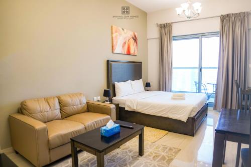 um quarto de hotel com uma cama e um sofá em Studio with burj view at Elite Business bay Residence by ANW vacation homes em Dubai