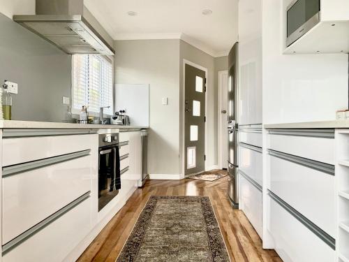 a kitchen with white cabinets and a rug at M&K Home with central air condition, 4 bedrooms, by Chartwell Shopping Centre in Hamilton