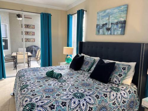 1 dormitorio con 1 cama grande y cortinas azules en Fab 5 bed Windsor Palms pool home. Disney 3 miles!, en Kissimmee