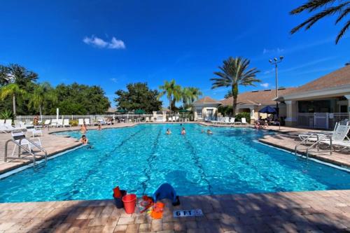 una gran piscina con gente en el agua en Fab 5 bed Windsor Palms pool home. Disney 3 miles!, en Kissimmee