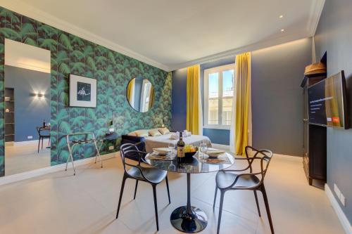 a living room with a table and chairs at Seven Suites Apartments - Via Matteotti 178 in Sanremo
