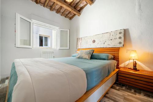 Schlafzimmer mit einem großen Bett mit einem Kopfteil aus Holz in der Unterkunft Ca la Rápita in Sant Carles de la Ràpita