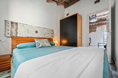 a bedroom with a large bed with a wooden headboard at Ca la Rápita in Sant Carles de la Ràpita