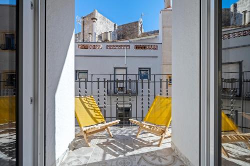 a pair of yellow chairs on a balcony at Ca la Rápita in Sant Carles de la Ràpita