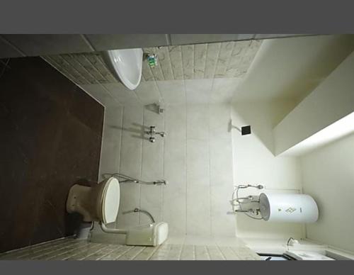 a bathroom with a toilet and a shower in it at La Exorete hotel in Shillong