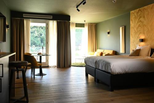 a bedroom with a bed and a table and a window at Wapen van Hengelo Residence Suites - digital key by SMS and email in Hengelo