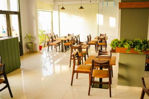 comedor con mesas y sillas de madera en Destination Beach Hotel by Dreamworld, en Karachi