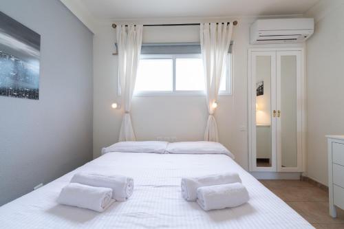 ein Schlafzimmer mit einem großen weißen Bett mit zwei Kissen in der Unterkunft Las Adelfas South Beach 5 By CanariasGetaway in San Bartolomé de Tirajana