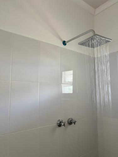 y baño con ducha con cabezal de ducha. en Ndau Lodge en Nkhata Bay