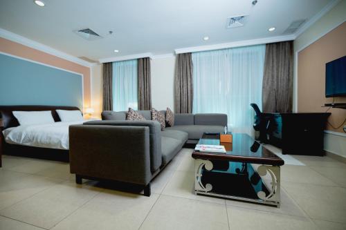 ein Wohnzimmer mit einem Sofa und einem Bett in der Unterkunft Laguna Hotel Suites in Kuwait