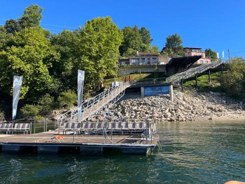 a dock with benches on the side of a river at Casa da Lage - Vistas rio - Gerês in Geres