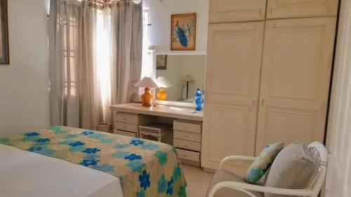 een slaapkamer met een bed, een bureau en een stoel bij Petit Coin de Paradis in Pointe aux Biches