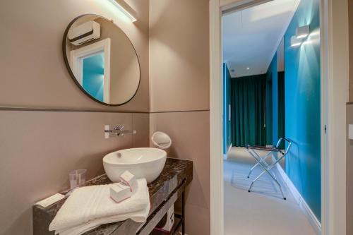 a bathroom with a sink and a mirror at Seven Suites Apartments - Via Matteotti 178 in Sanremo