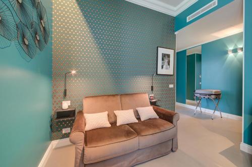 a living room with a brown couch and blue walls at Seven Suites Apartments - Via Matteotti 178 in Sanremo
