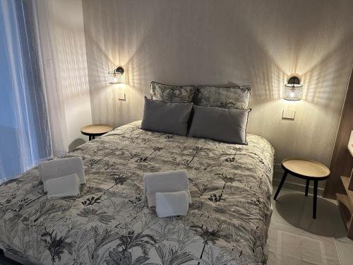 1 dormitorio con 1 cama grande y 2 mesas en RESIDENCE Neuve LE GALATEE PIED DANS L'EAU, en Porticcio
