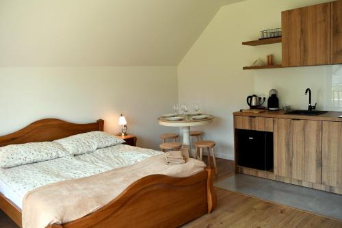 a bedroom with a bed and a table and a kitchen at Dobranocka Noclegi - blisko Energylandia in Spytkowice