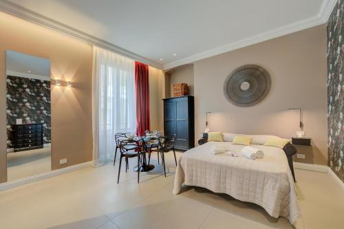 a bedroom with a bed and a table and chairs at Seven Suites Apartments - Via Matteotti 178 in Sanremo