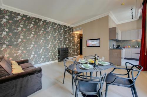 a living room with a table and chairs and a couch at Seven Suites Apartments - Via Matteotti 178 in Sanremo