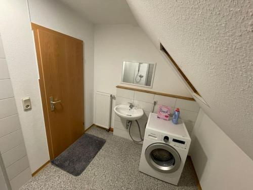 une petite salle de bains avec un lave-linge et un lavabo dans l'établissement Südbahnhof, à Marbourg