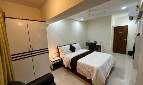 a small bedroom with a bed and a kitchen at FabHotel Prime Finesse in Kharadi