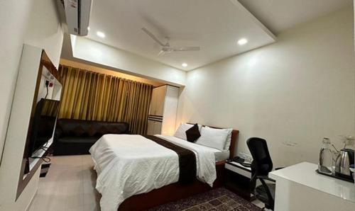 Habitación de hotel con cama y silla en FabHotel Prime Finesse en Kharadi