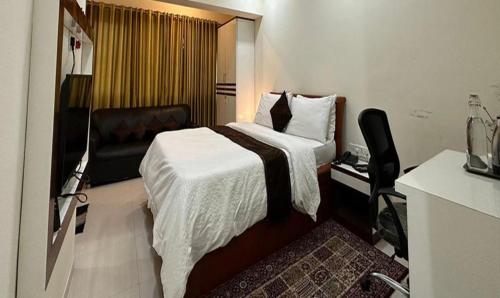 a hotel room with a bed and a chair at FabHotel Prime Finesse in Kharadi