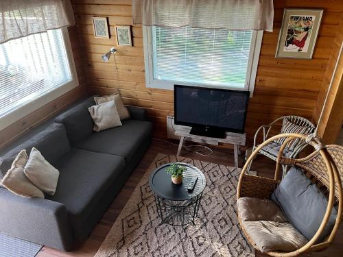 ein Wohnzimmer mit einem Sofa und einem TV in der Unterkunft Vikajärvi Lake View Experience Igloos in Rovaniemi